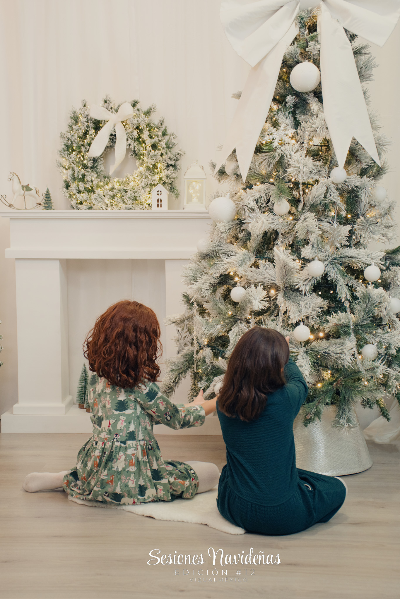 Foto de hermanas sentadas junto al árbol de navidad