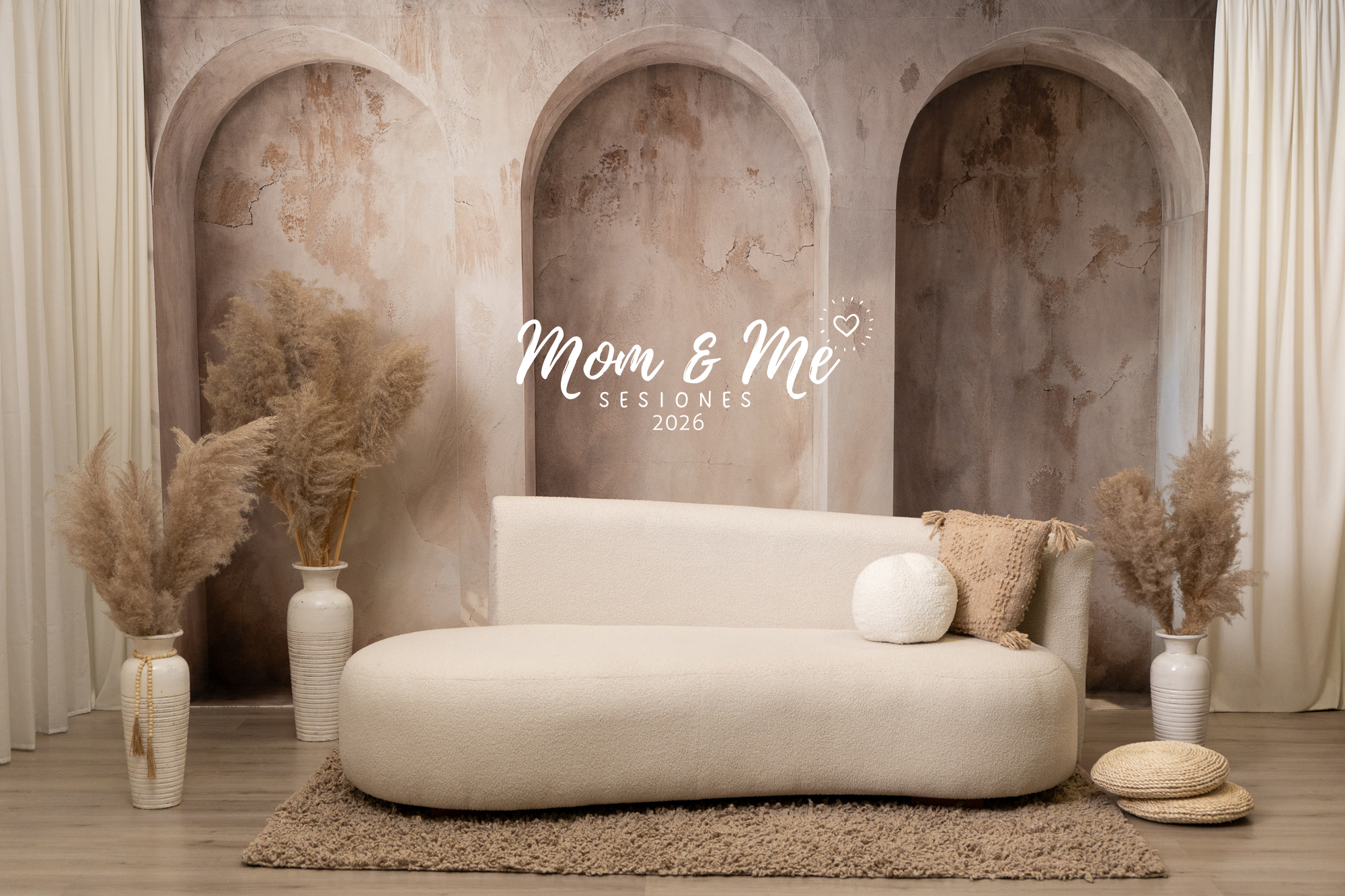 Sesiones 10 de mayo con mamá e hijos en set elegante con pampas, tonos café, sillón orgánico y fondo con arcos en estilo alcoba, creando un ambiente cálido y natural
